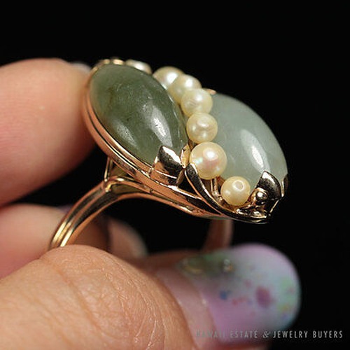 Angled view of the ring showing its paired jade forms and pearl accents.