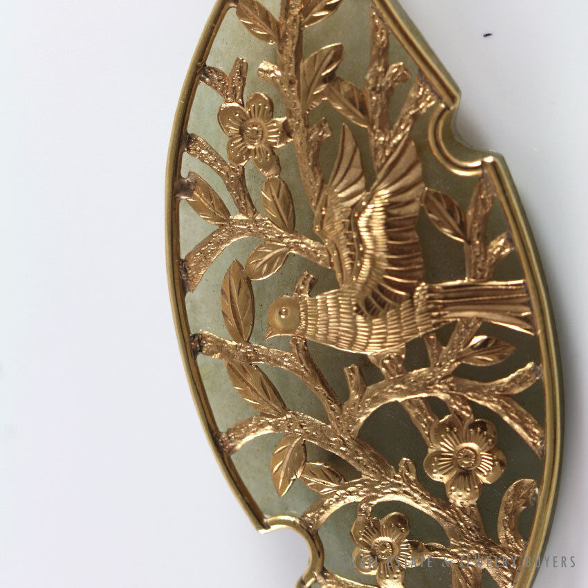 Close view of the engraved bird, blossoms and branches.