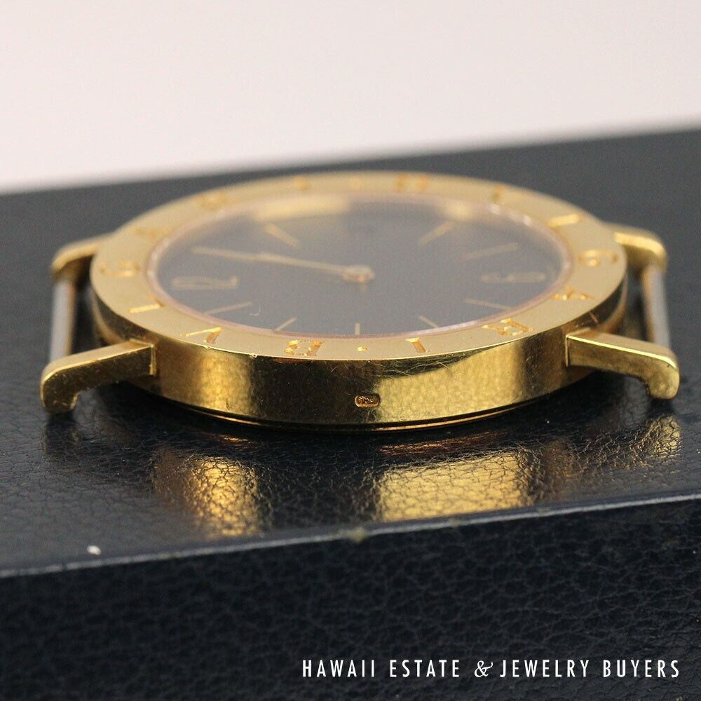 Opposite side of the gold watch case, showing its profile and empty strap lugs.