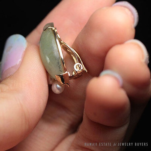 Side view of an earring showing its jade, pearl accents and hinged fitting.