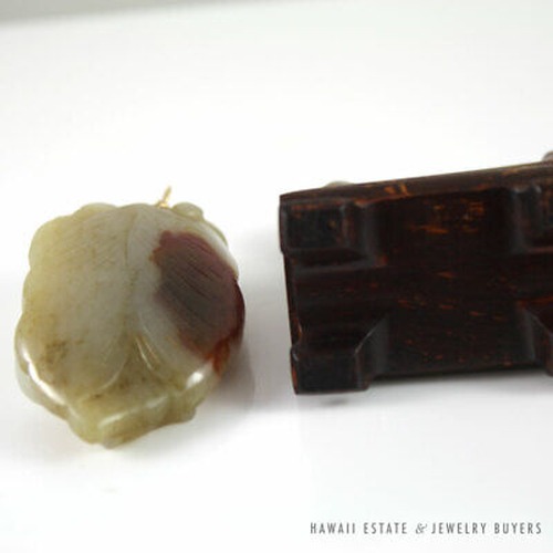 Reverse of the jade carving beside the wooden stand.