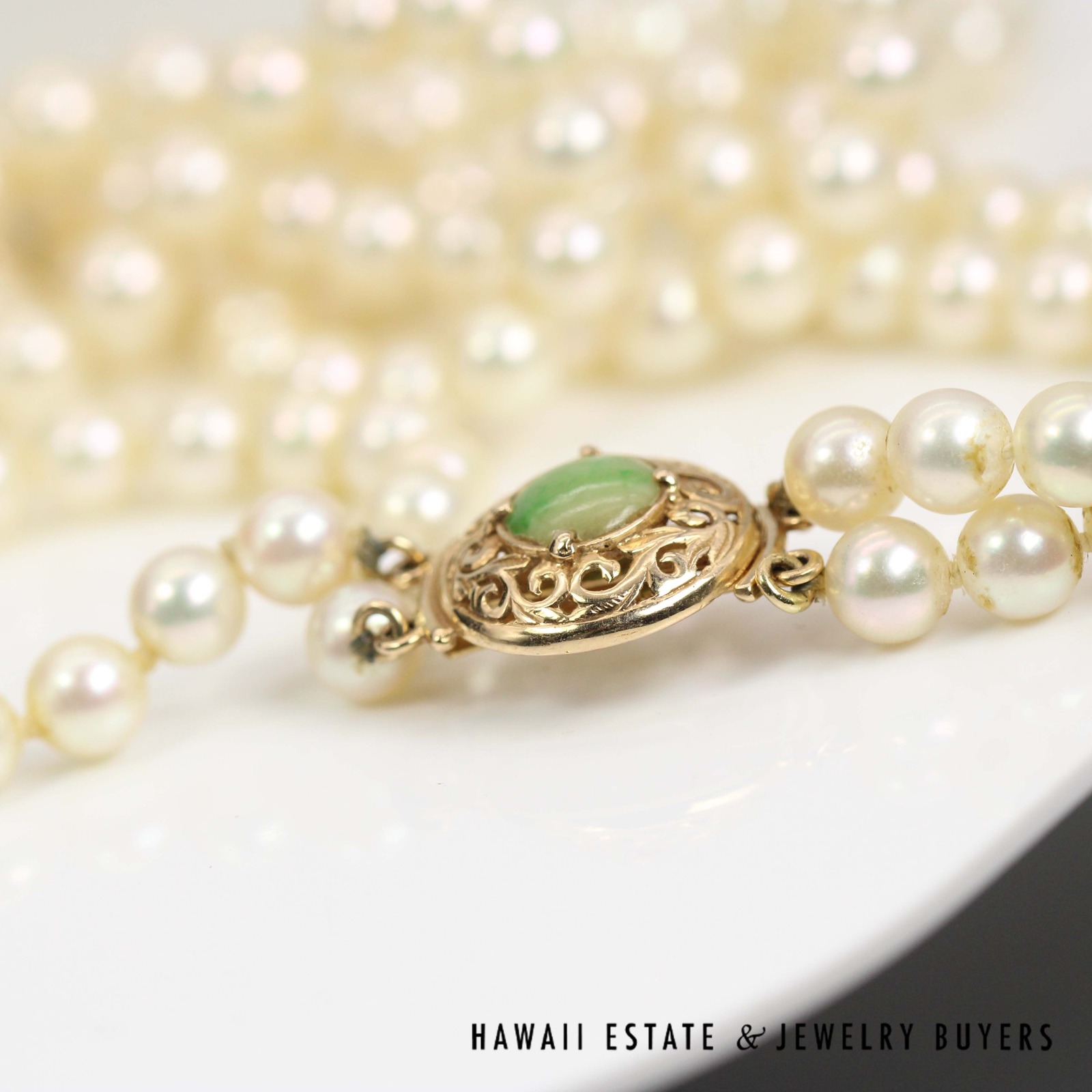 Close view of the jade clasp and its surrounding open gold scrollwork.