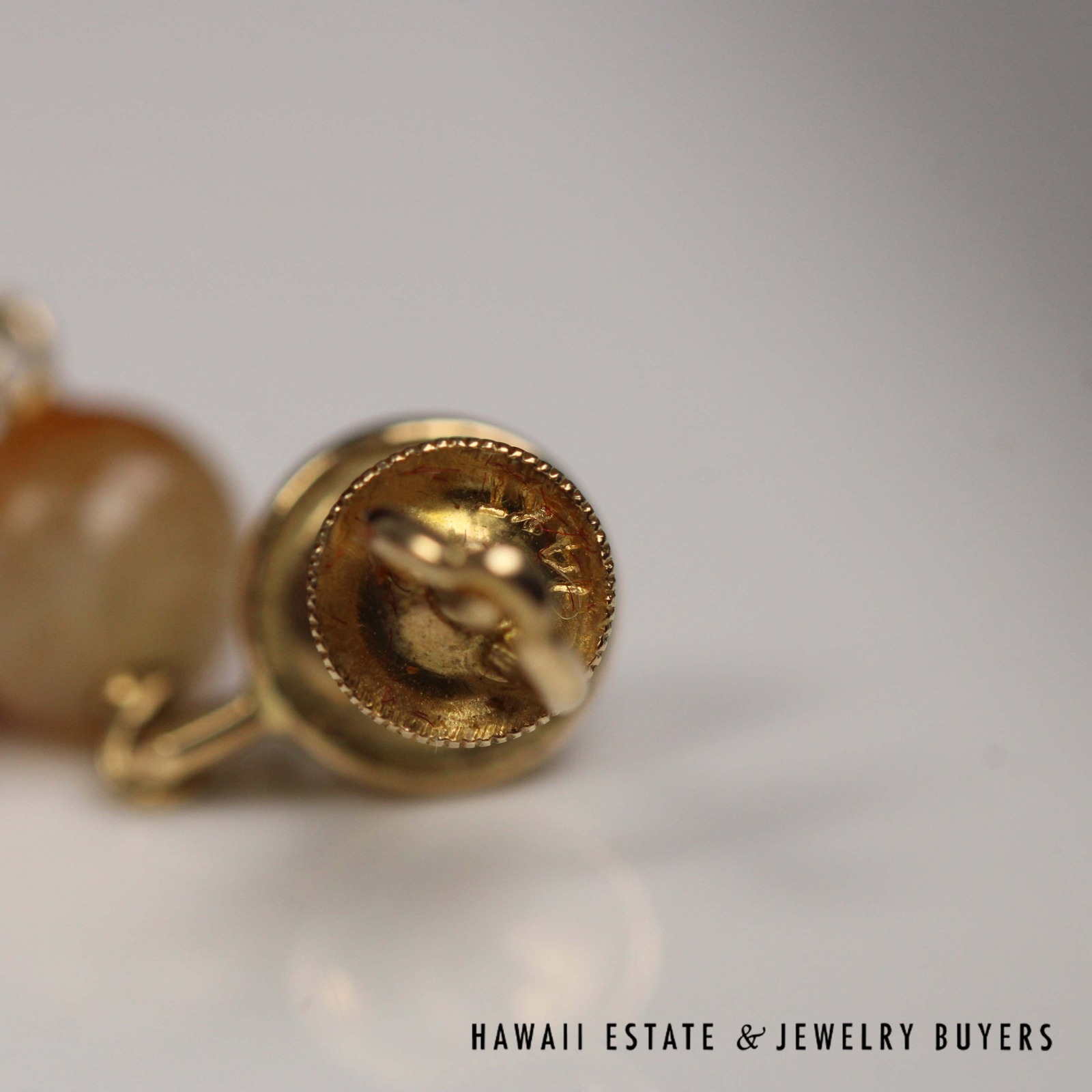 Close view of a round earring clutch and its stamped area.