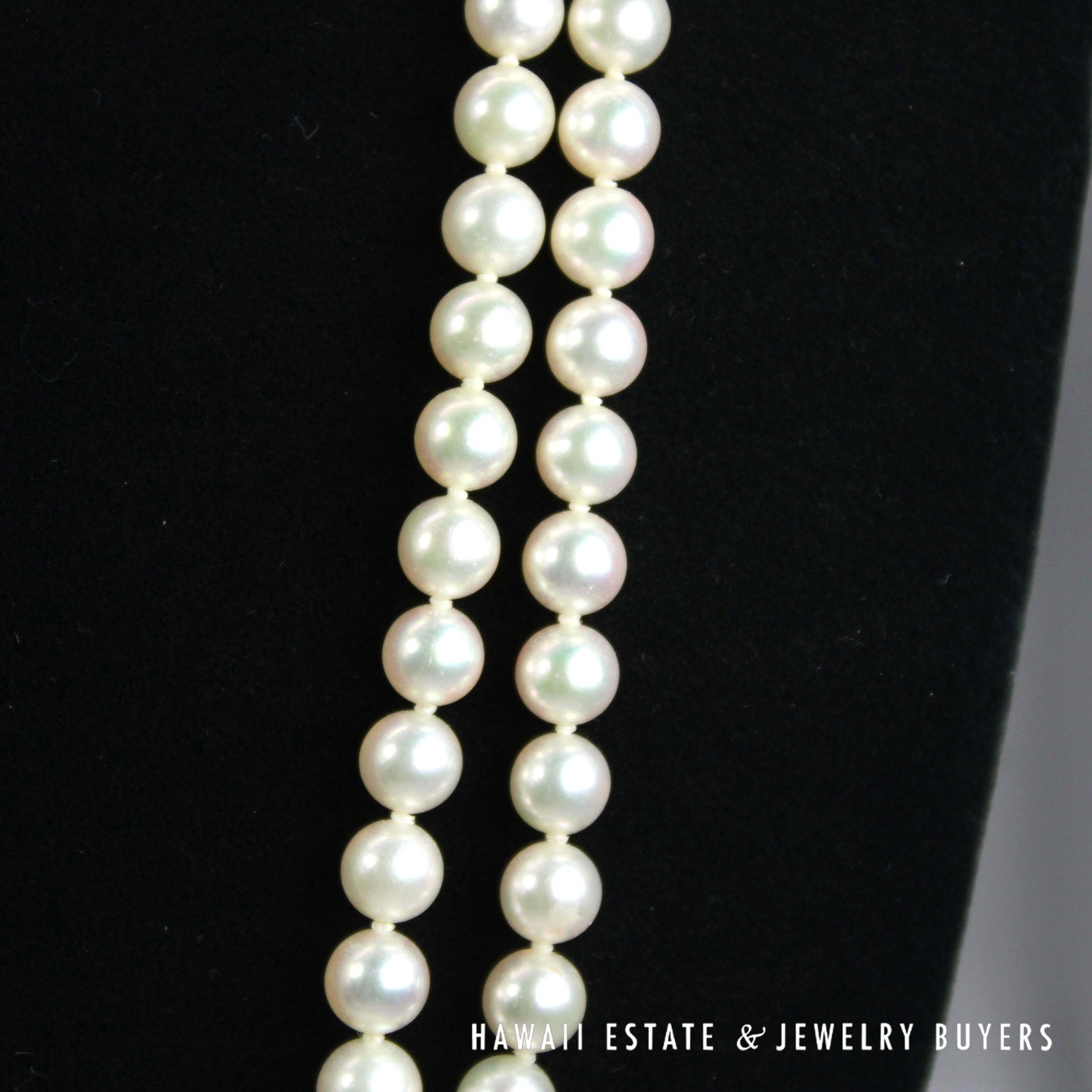 Close view of the parallel pearl strands against a black background.