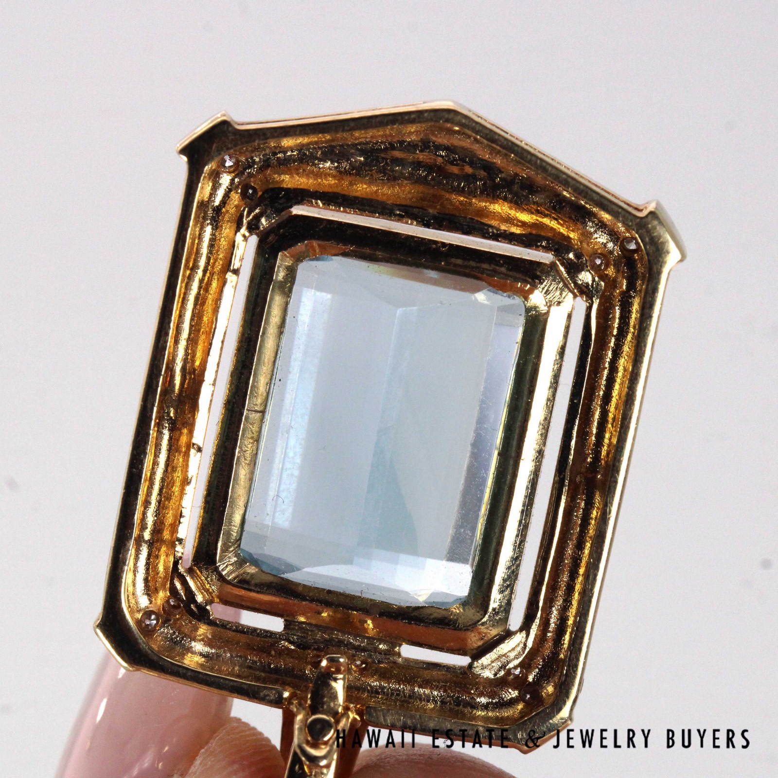Close rear view of the topaz and surrounding gold frame.