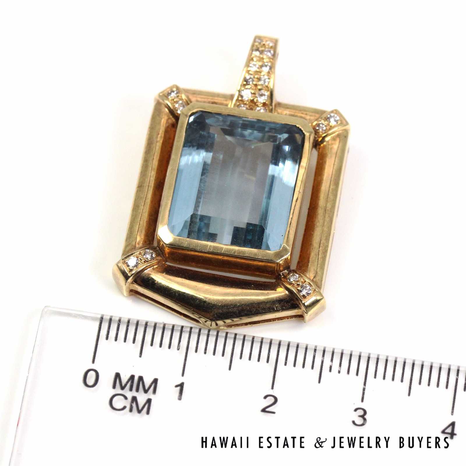 Front view of the pendant beside a ruler to show its width.