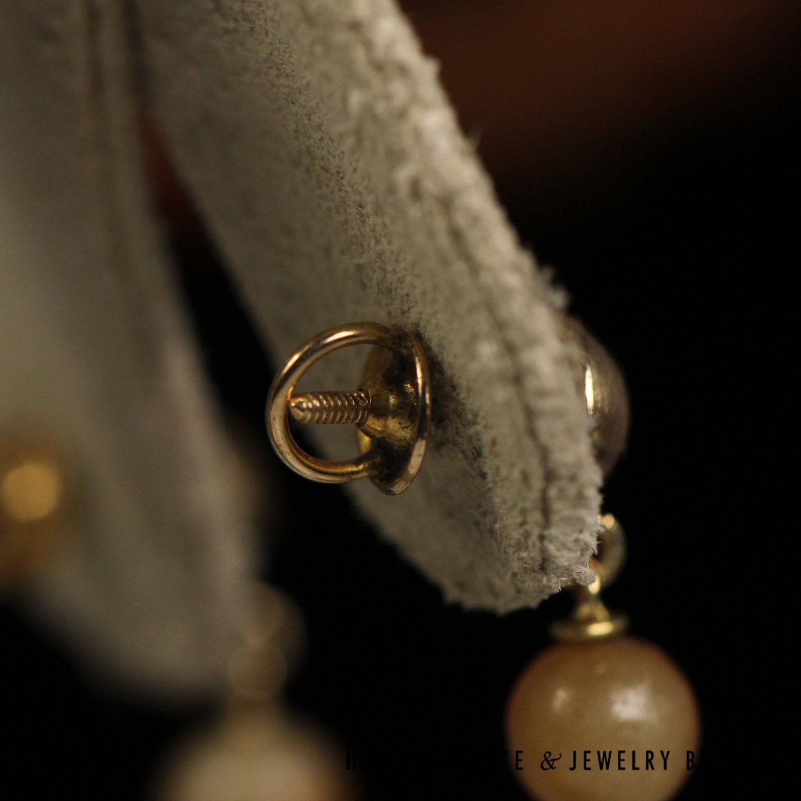 Close rear view of an earring's threaded post and clutch.