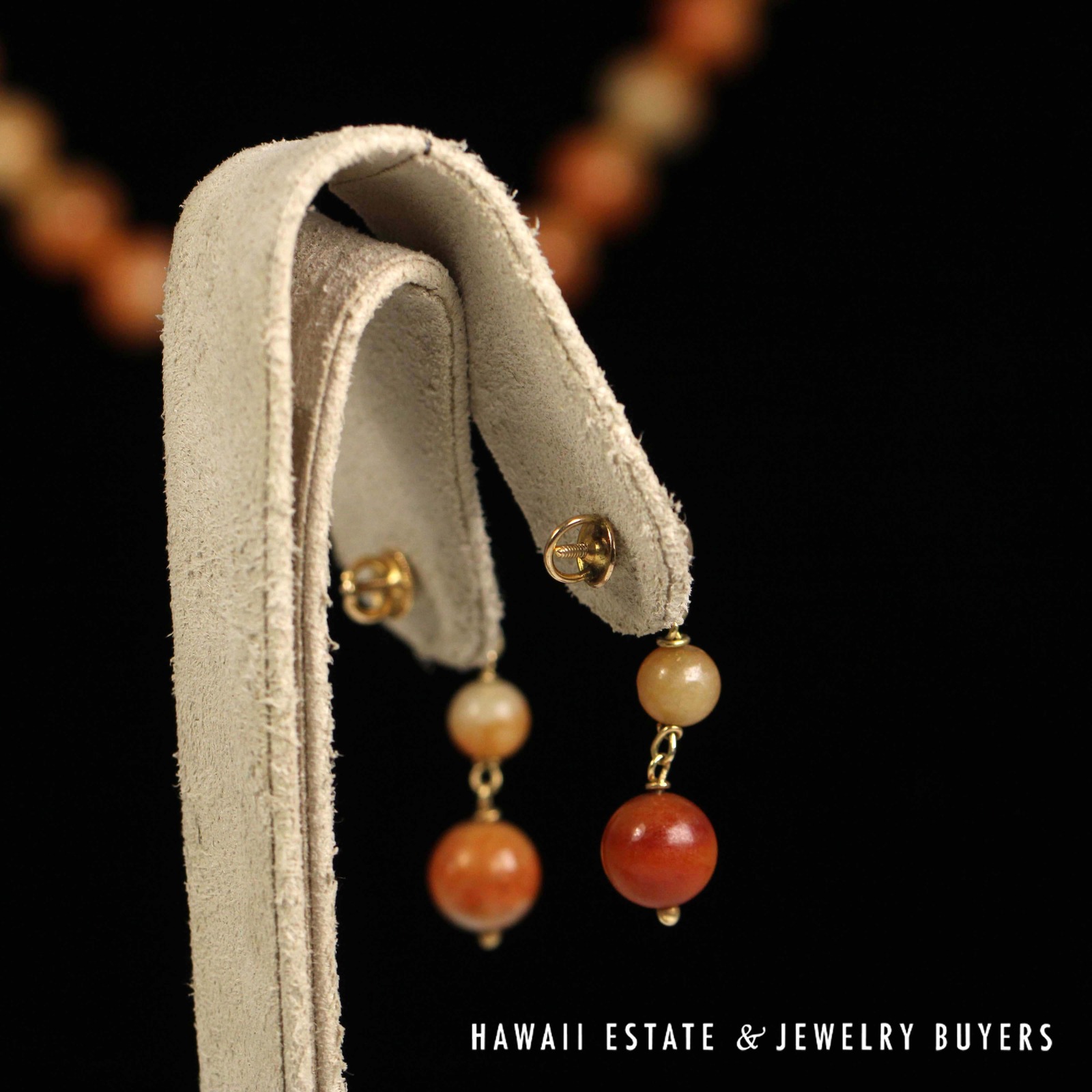 Rear view of the drop earrings on a stand, showing their clutches.