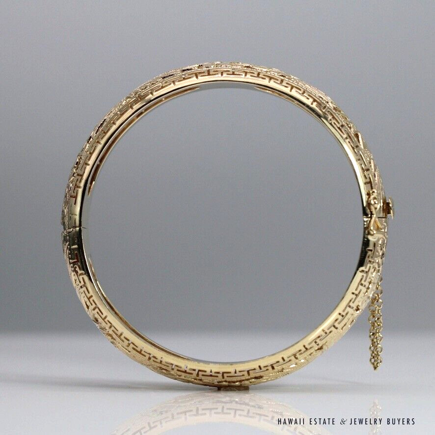 Po Sun Hon bangle standing upright, showing its circular opening, patterned edge and hanging safety chain.