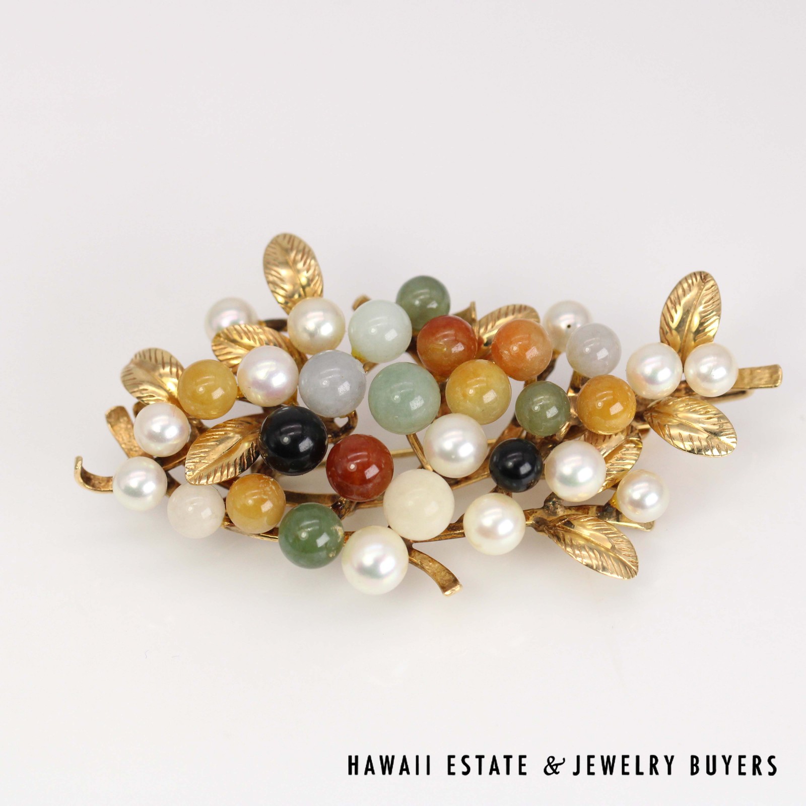 Front of the jade bead cluster brooch showing pale accents and veined gold leaves.