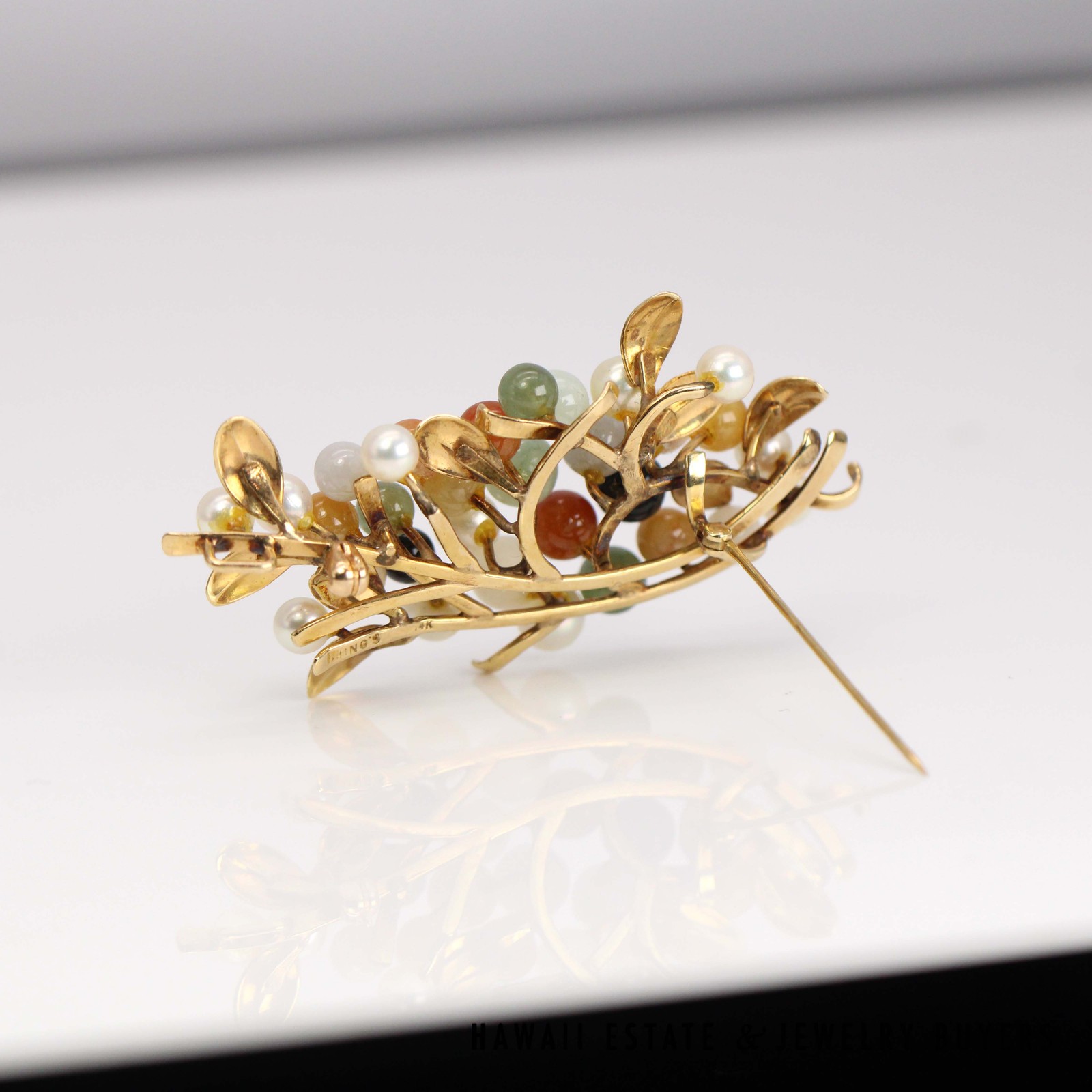 Back of the multicolored brooch showing the branching gold framework and open pin.