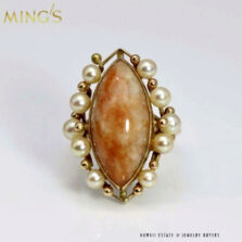 Front view of the marquise brown jade ring bordered by pearls and gold beads.