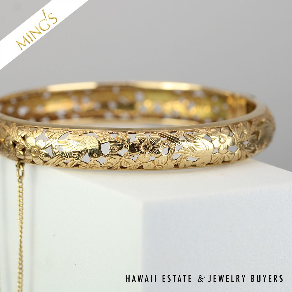 Front of the slender gold bangle showing engraved birds among plum blossoms.