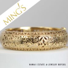 Close view of the Shou motifs, curling leaves and geometric borders on the yellow gold bangle