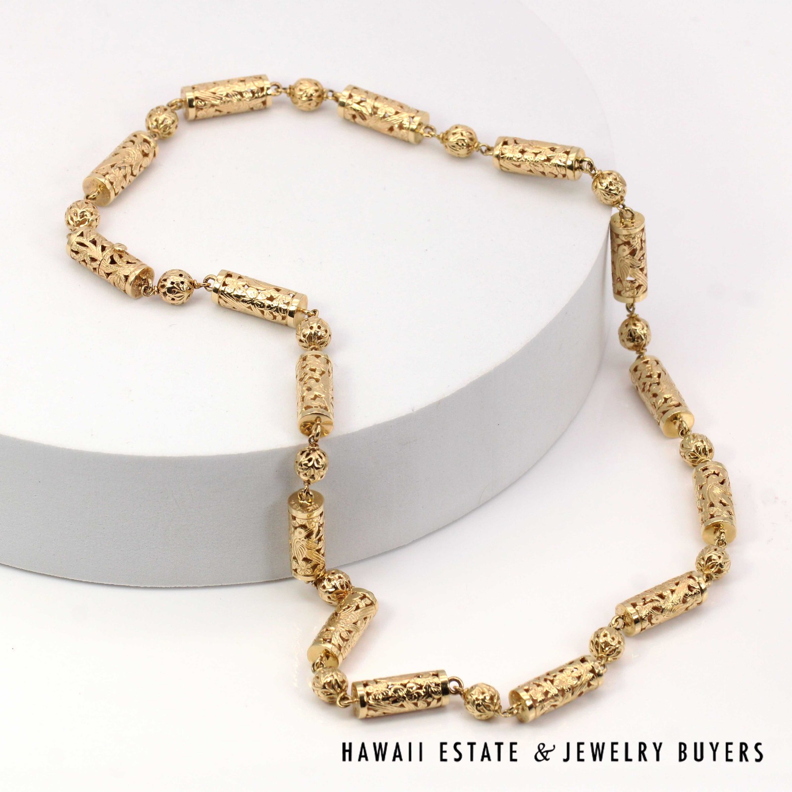 Full gold bead necklace arranged around a white circular display.