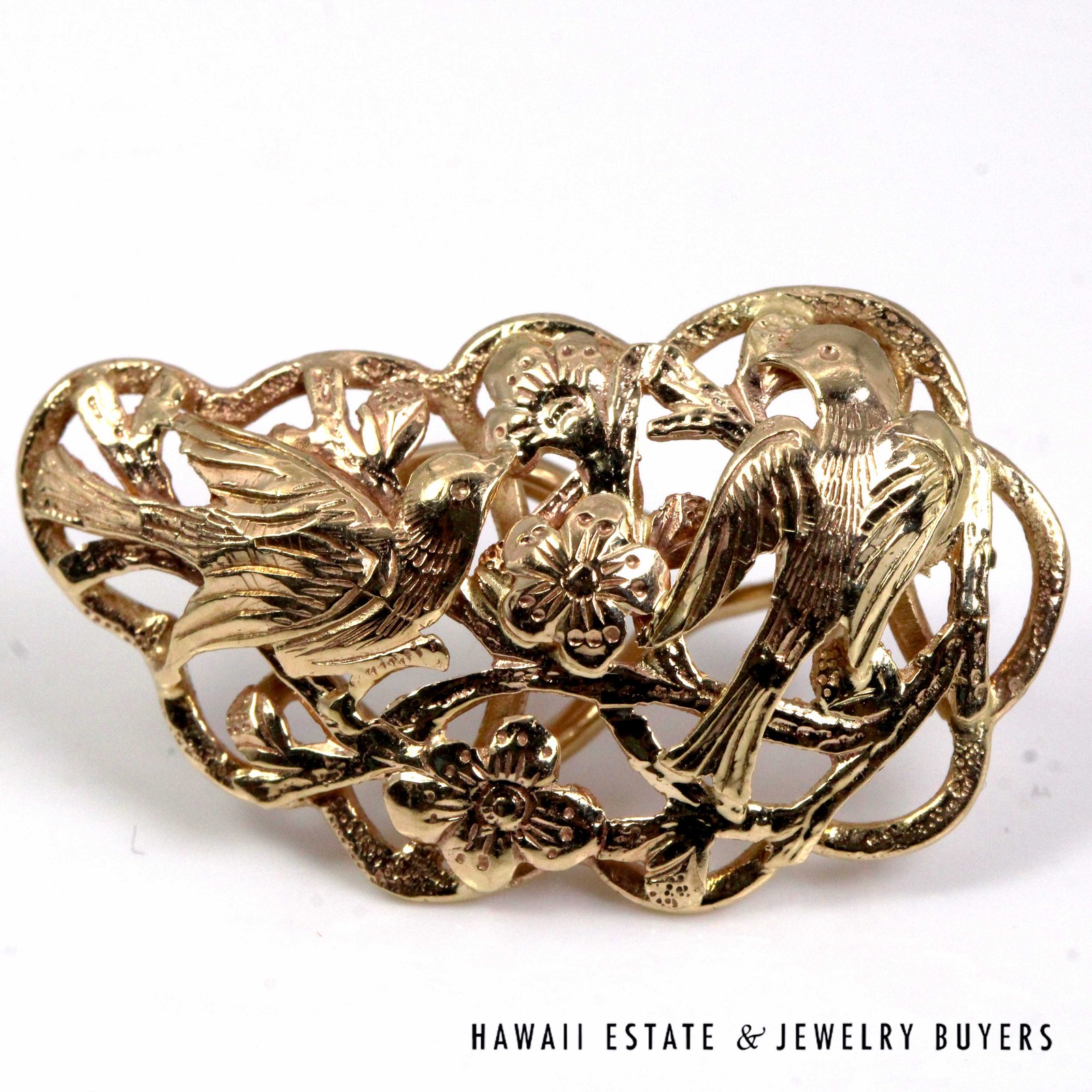 Close-up of the birds, feather details and blossoms on a gold earring.