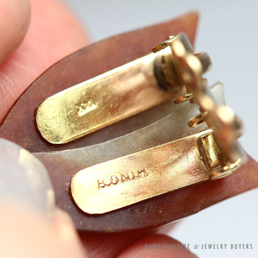 Close view of the earrings' gold backs and stamped areas.