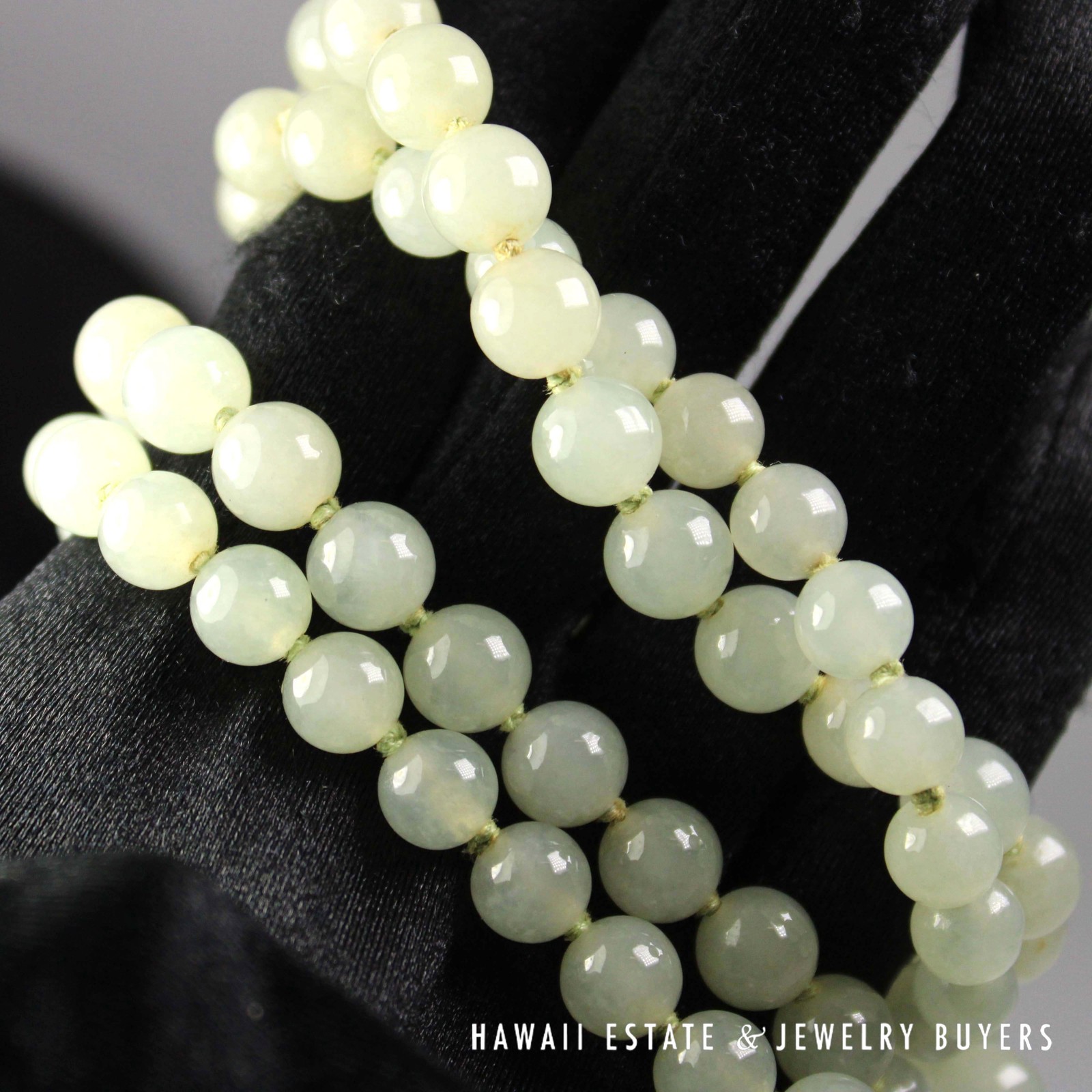 Close-up of the jade beads and knots on a black glove.