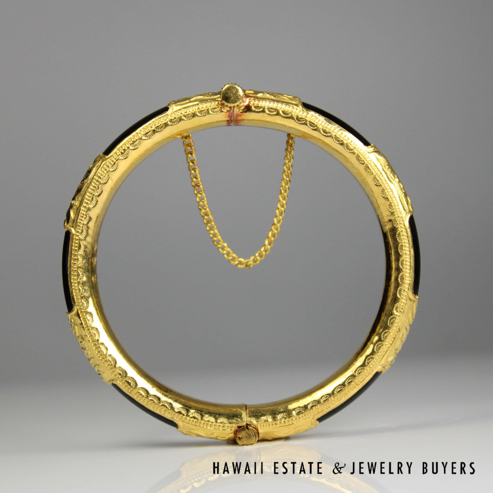Upright view of the closed bangle showing the patterned inner border and chain.