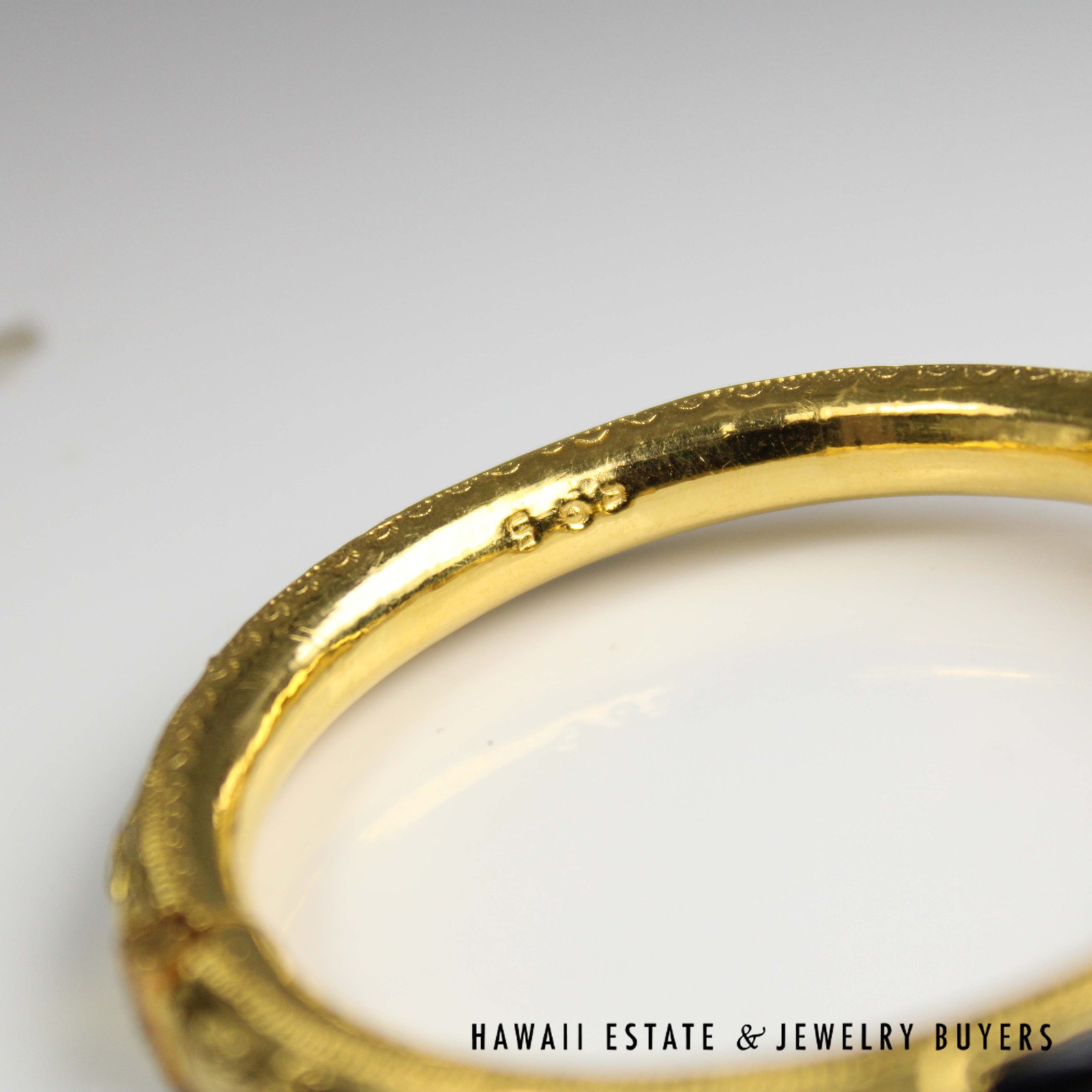 Close view of a small stamped mark on the bangle's inner surface.